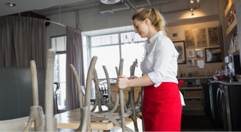 Waitress arranging chairs in a restaurant