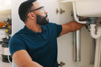 Man with safety glasses working on a drain