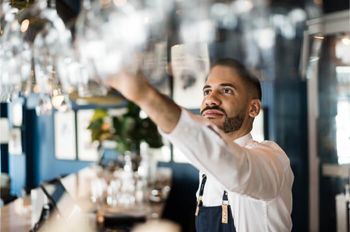 Bartender arranging glasses