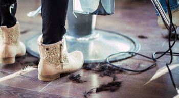 boots standing on salon floor covered in hair