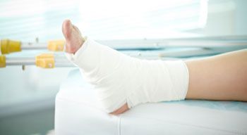 bandaged foot propped up on hospital bed