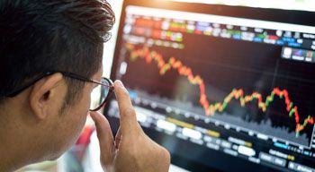 man looking at stock market chart on computer