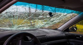 view from inside of car at broken windshield