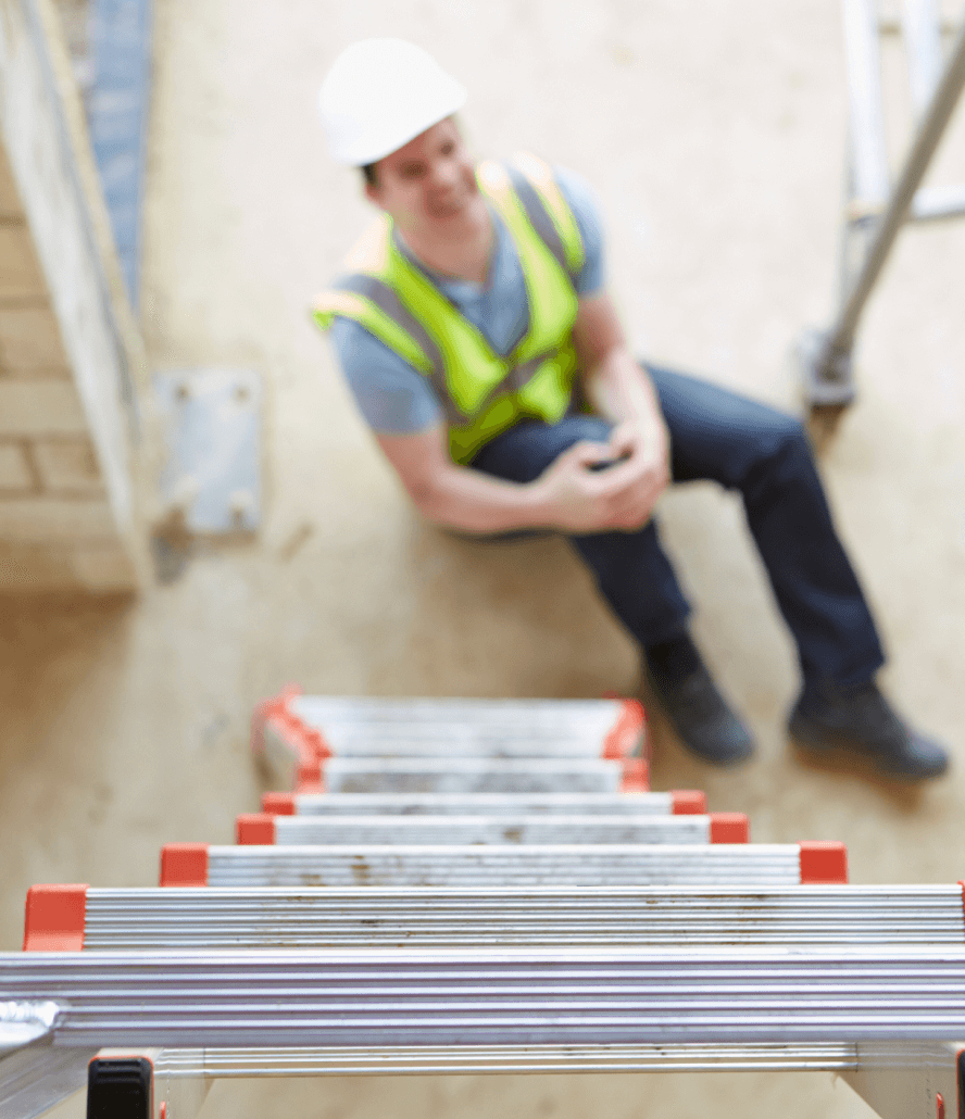 Worker in construction gear grasping knee after falling off ladder