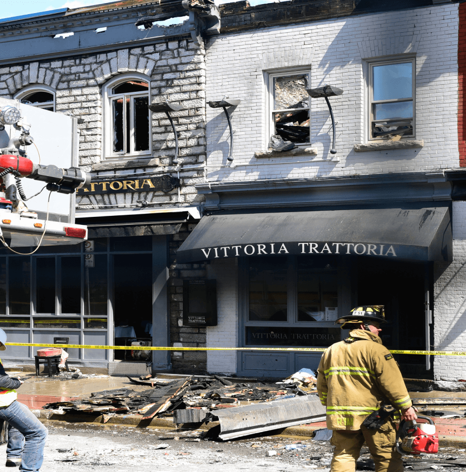 Firefighter standing outside of restaurant looking at the aftermath of a fire