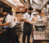 Chefs in industrial restaurant kitchen preparing food