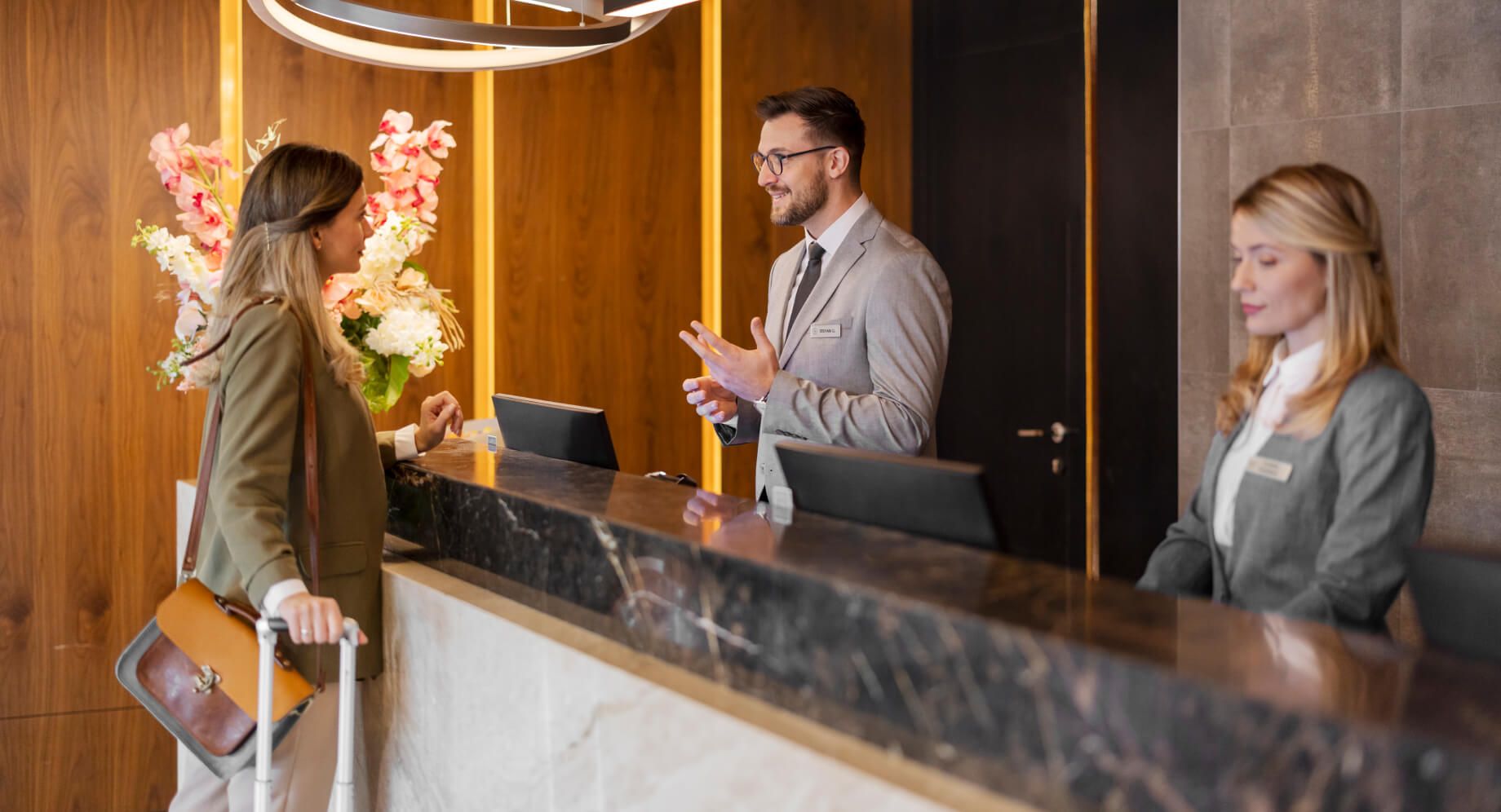 Woman checking into the front desk of a hotel