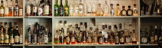 bottles of liquor on shelves on wall of bar