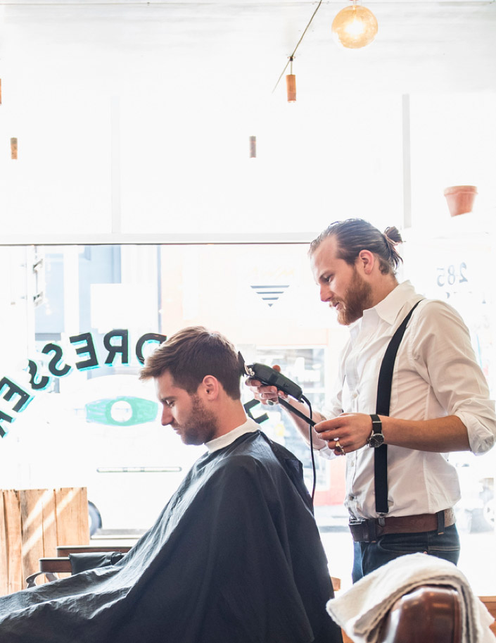 Stylist trimming hair of customer in barber shop